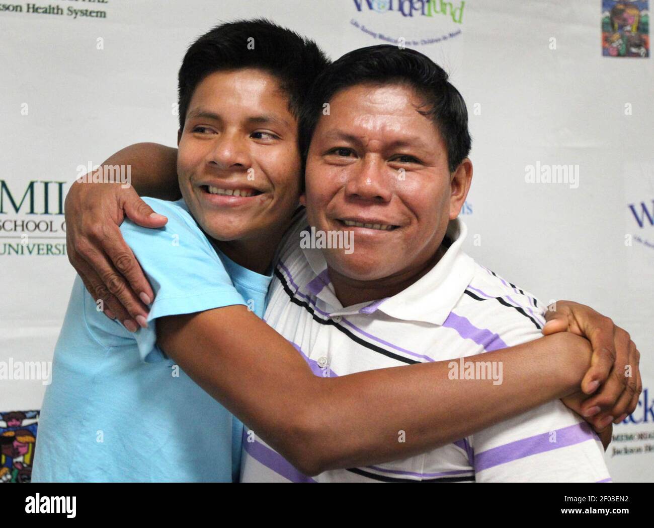 Luis Canelos hugs his father Roger Canelos during a press conference at