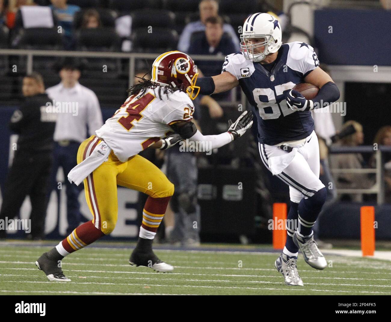 Dallas Cowboys tight end Jason Witten (82) stiff arms Washington Redskins  strong safety DeJon Gomes (24) on a 4-yard pass play in the third quarter  at Cowboys Stadium in Arlington, Texas, on