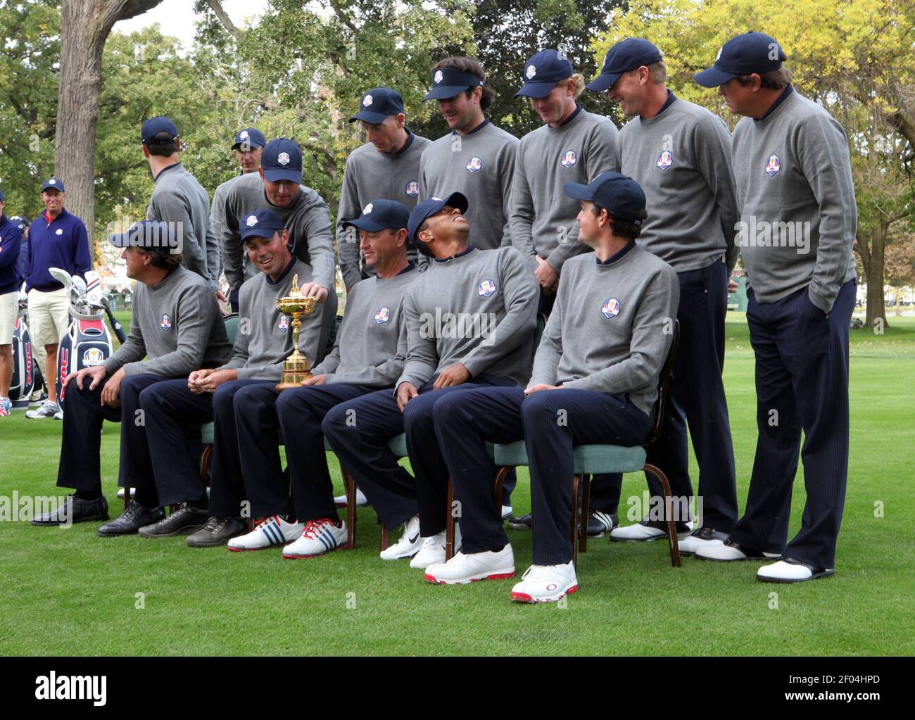 Tiger Woods, front row, second from right, looks back at teammates after someone popped his cap forward as the U.S