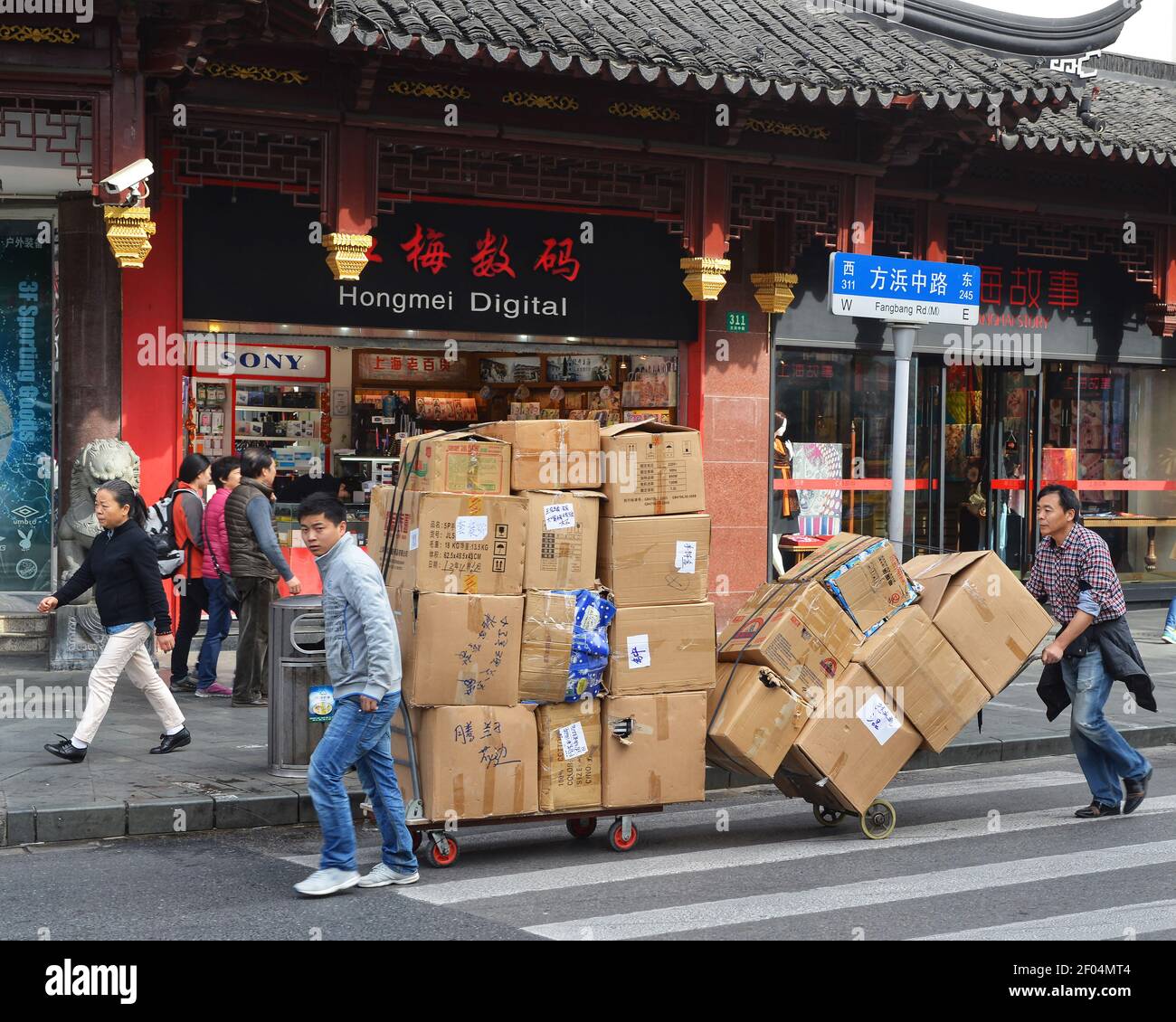 Shanghai, China November 12, 2014 Two men move large boxes on carts