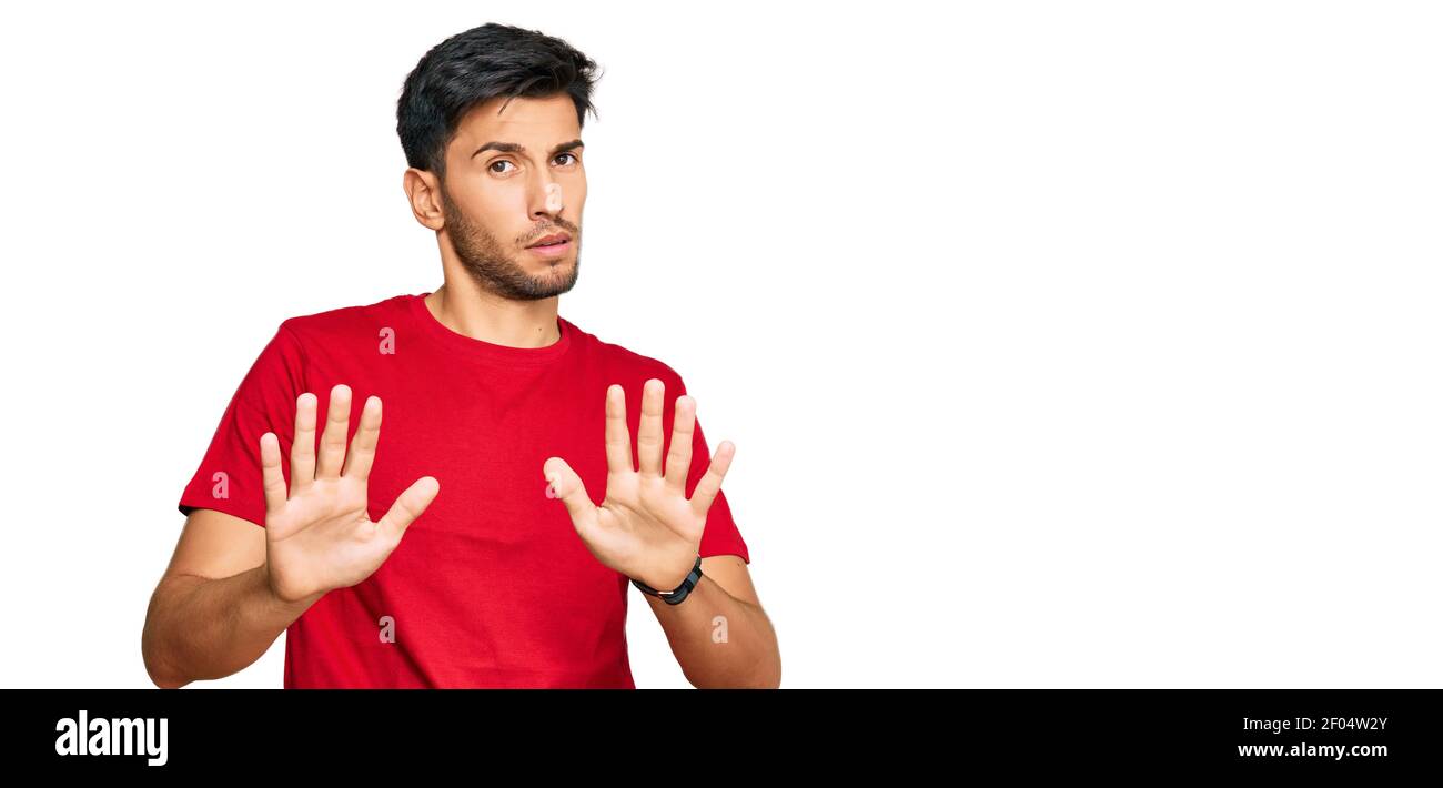 Young handsome man wearing casual red tshirt moving away hands palms ...
