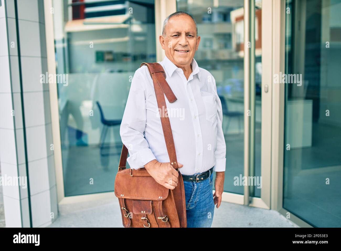 Senior businessman smiling happy walking at the city Stock Photo - Alamy
