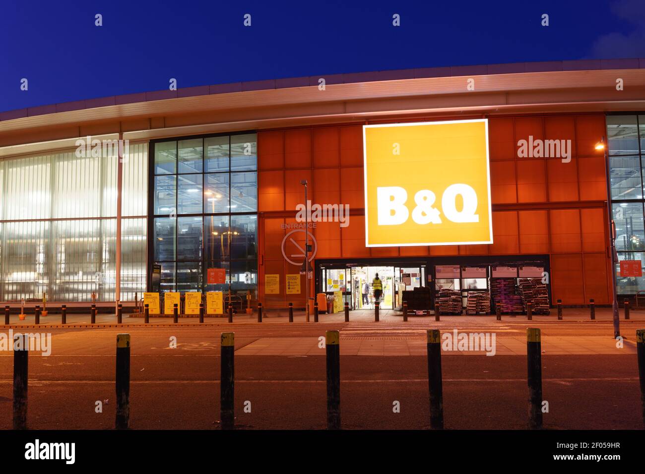 B&Q store entrance lit up at evening shopping hours in London, white ...