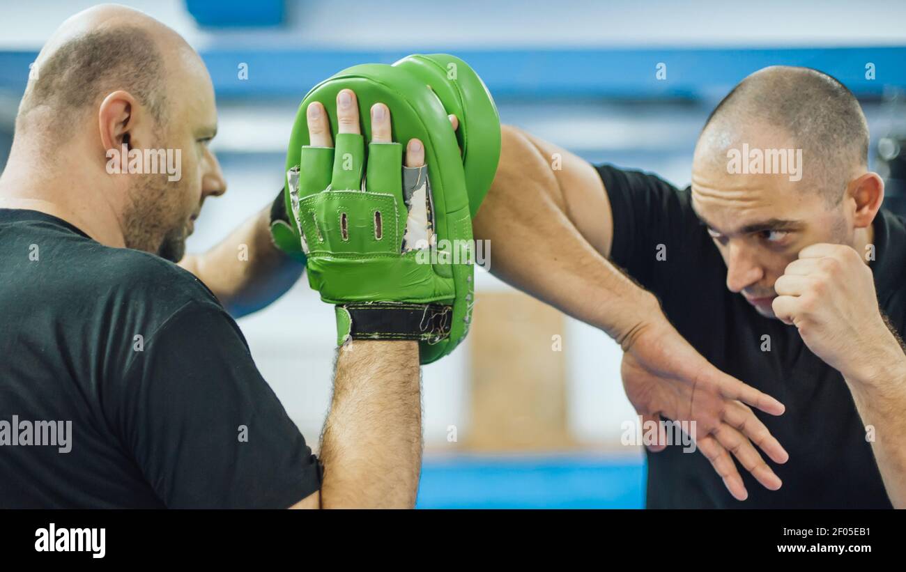 Elbow kick technique training with focus mitts. Elbow strike and punch