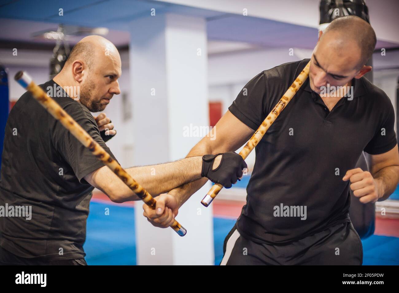 Instructor and student practice filipino escrima stick fighting