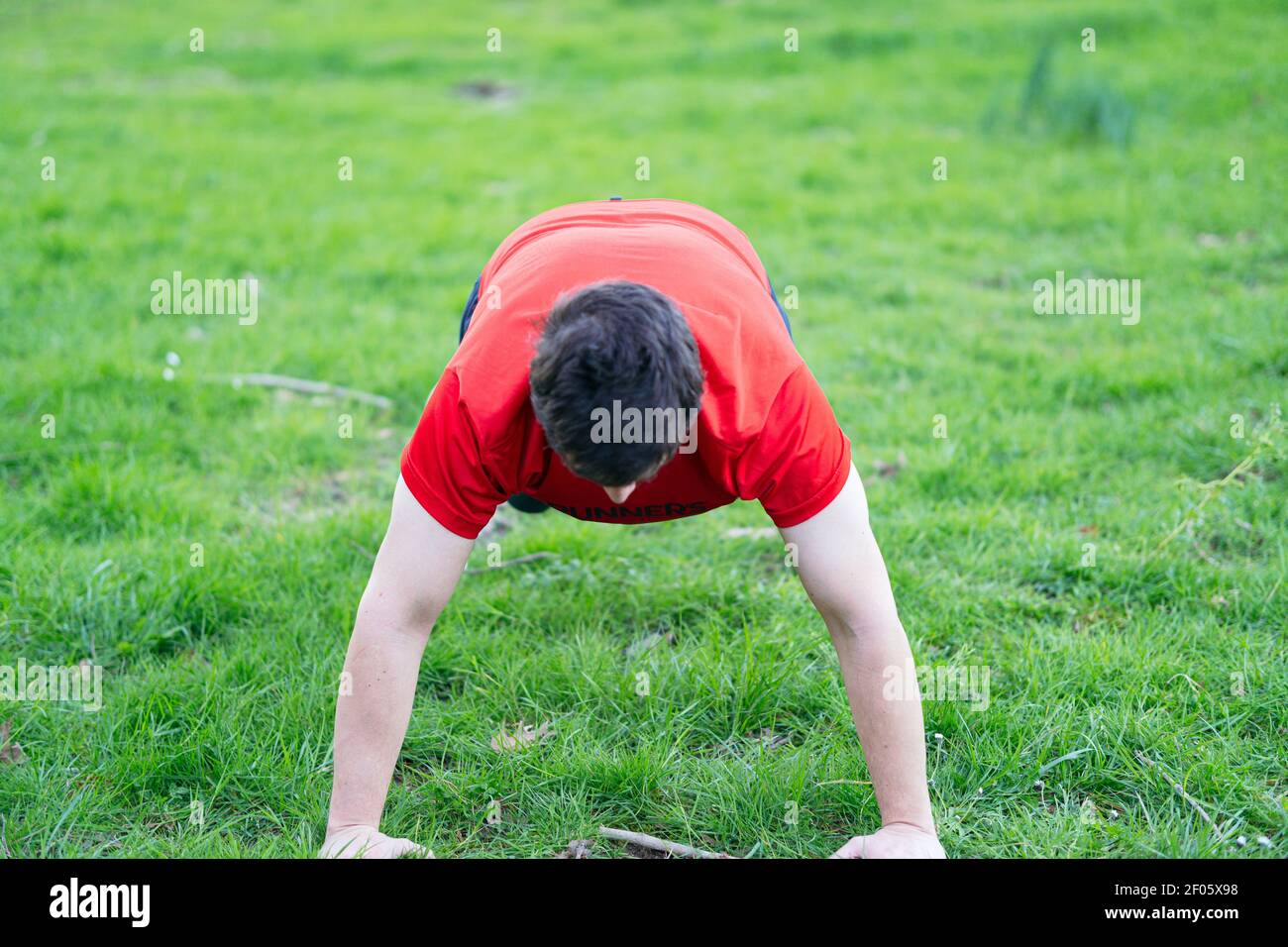 overweight man doing sports in a park. push ups in the grass Stock ...