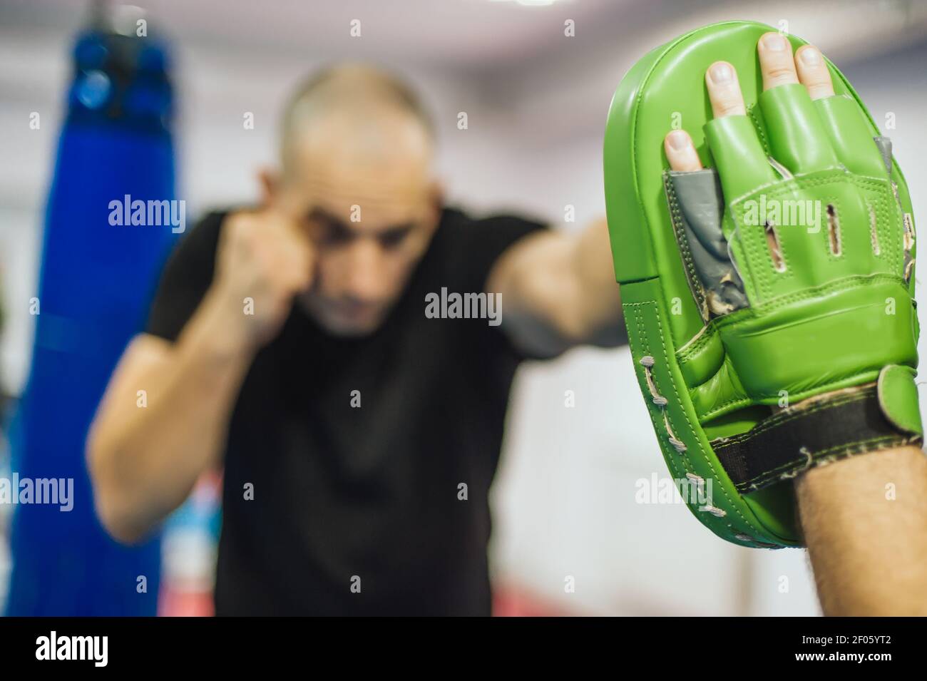 Instructor holds focus mitts. Boxing kick training and demonstration