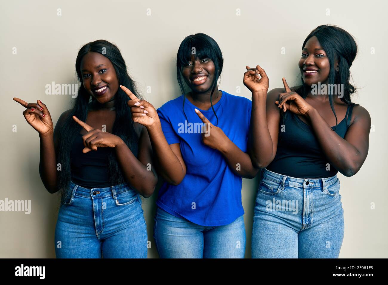 Three young african american friends wearing casual clothes smiling and ...