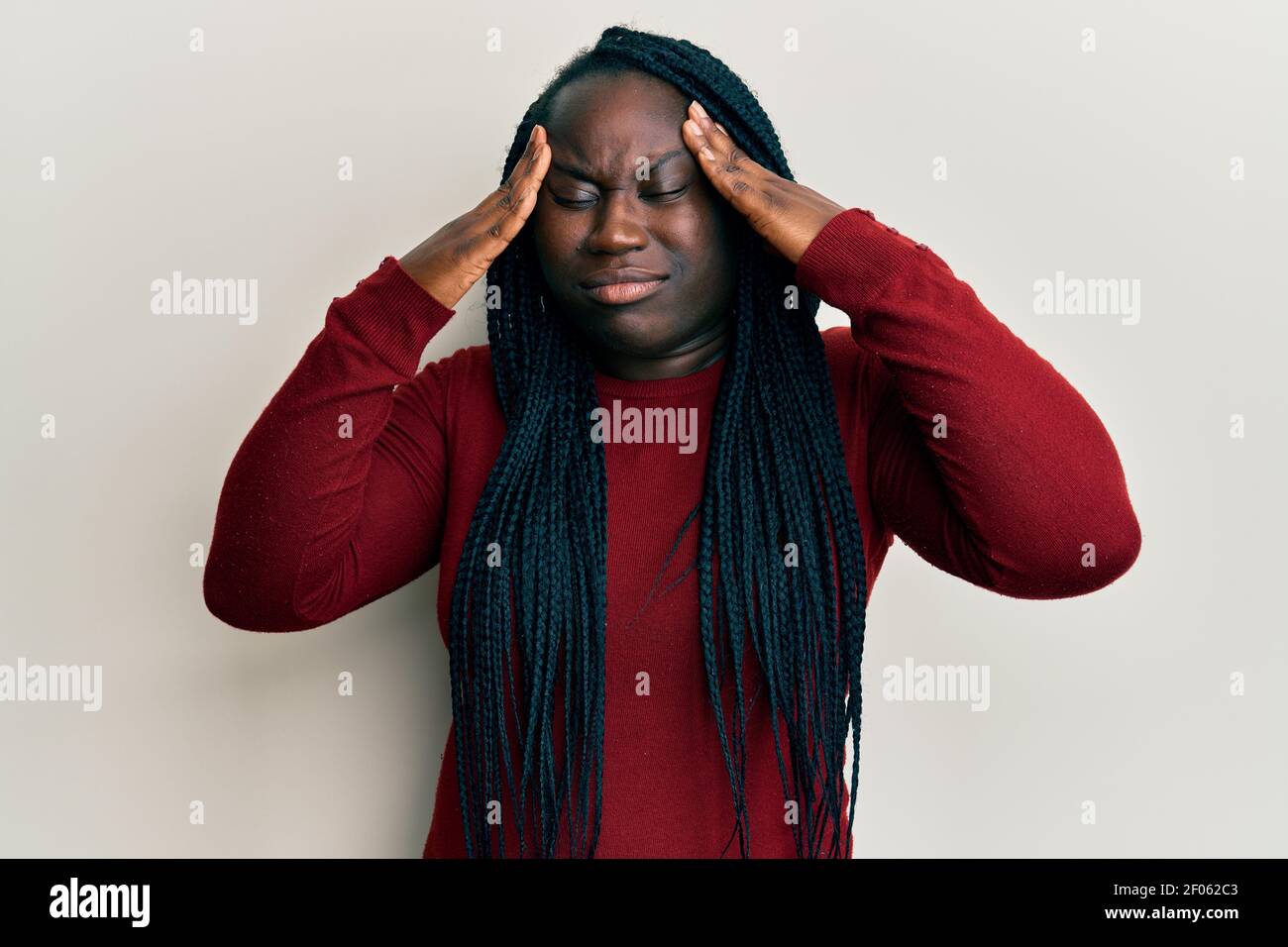 Young black woman with braids wearing casual clothes with hand on head