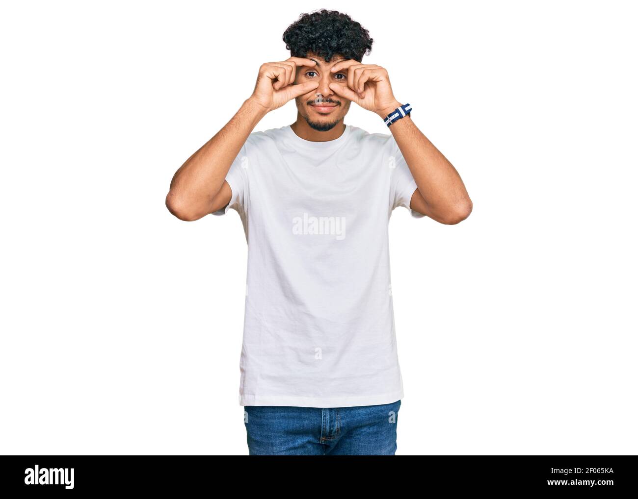 Young arab man wearing casual white t shirt trying to open eyes with ...