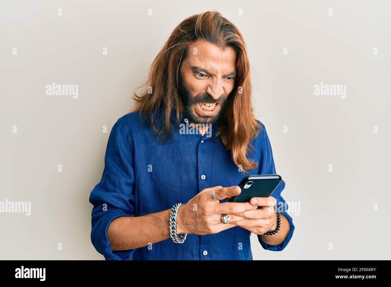 Premium Photo  Handsome bearded guy holds smartphone and plays online games  joyful man wearing a black stylish hat and a blue shirt crazy emotions