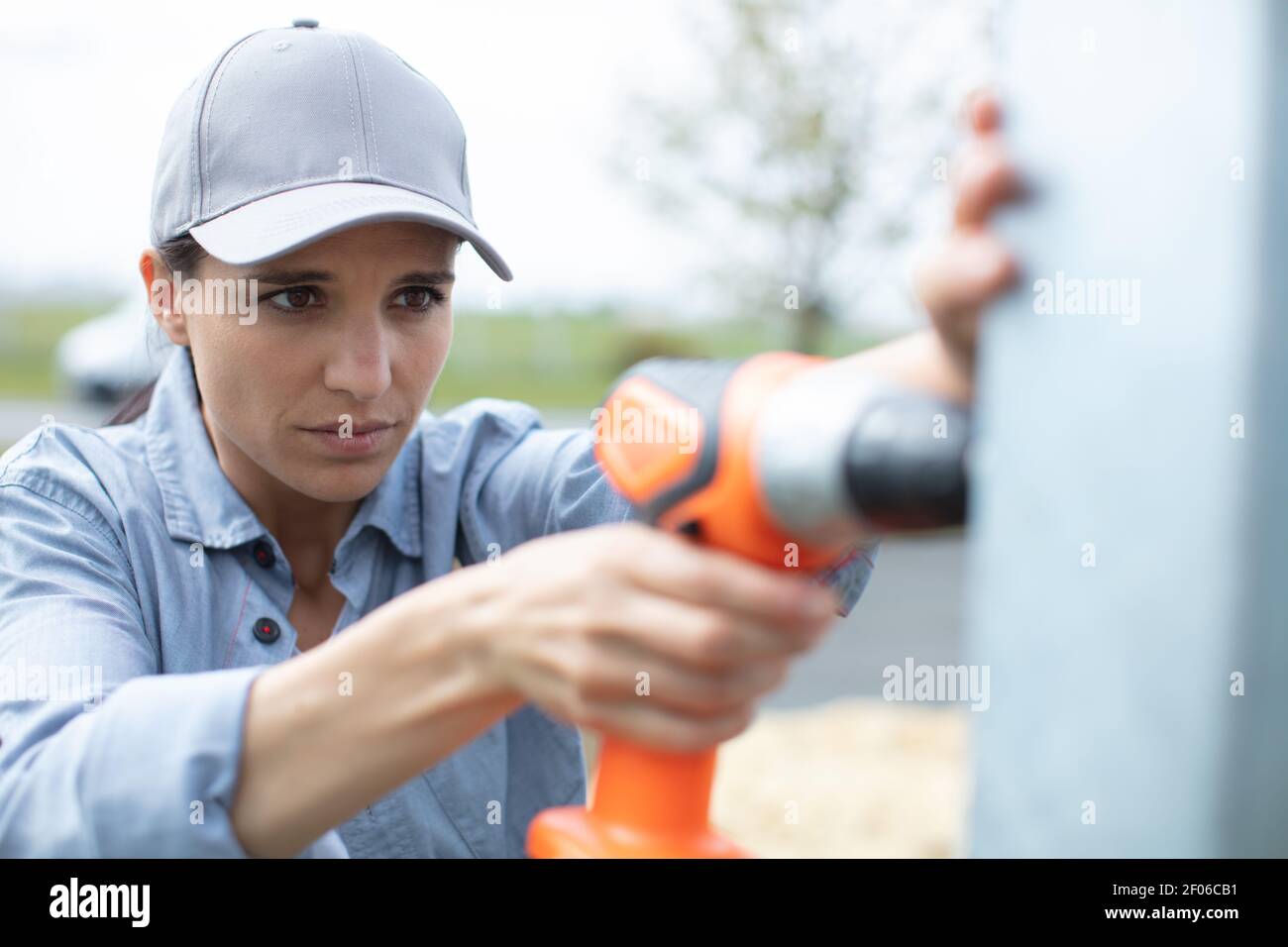 serious girl using a battery drill Stock Photo