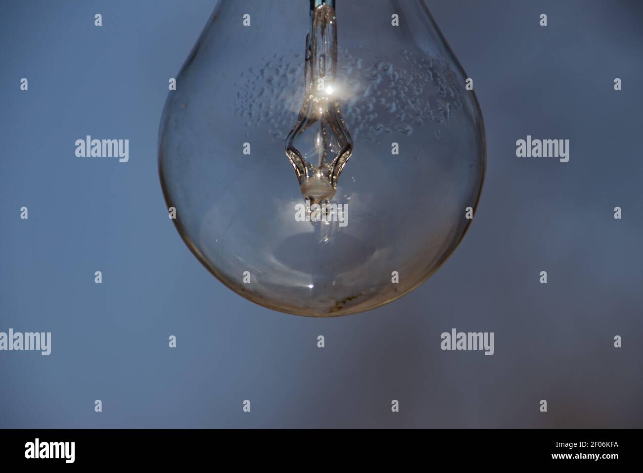 Close up of a vintage lightbulb hanging outdoors with condensation droplets inside Stock Photo