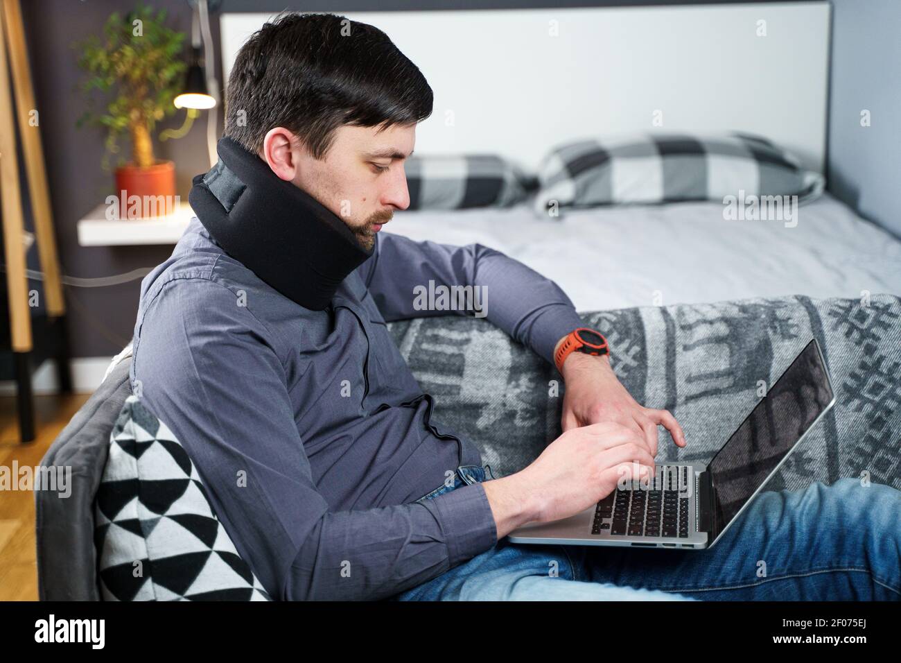 Tired strained man suffering from neck pain while working at computer