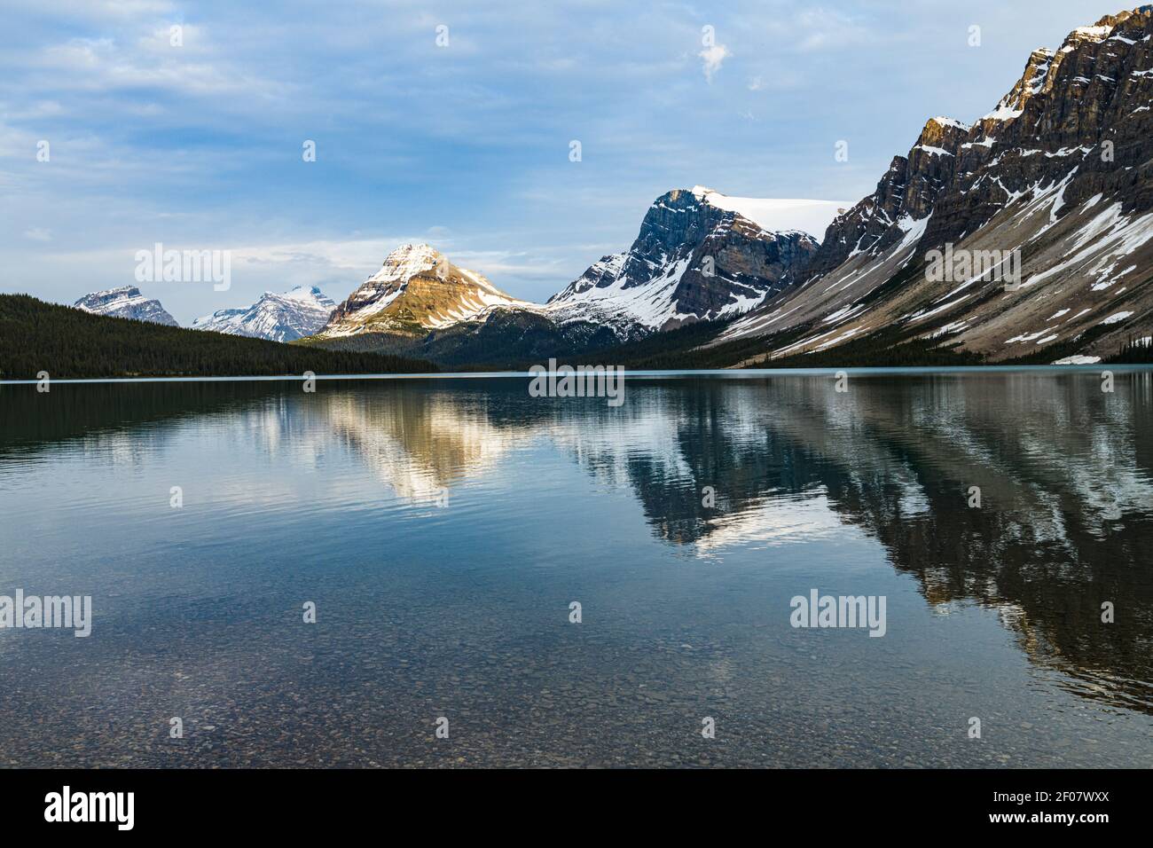 Calm waters and reflections high in the Canadian Rockies at Bow Lake on the edge of the Icefields Parkway in Banff National Park Stock Photo