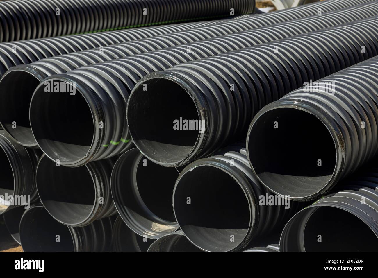 PVC tubes plastic pipes stacked in rows at construction site on