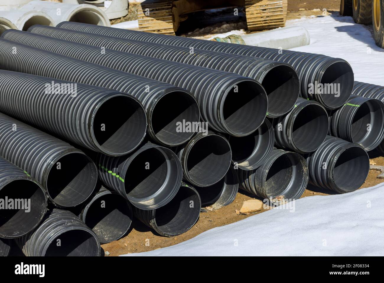 Plastic PVC pipes stacked in rows at a construction site on ...