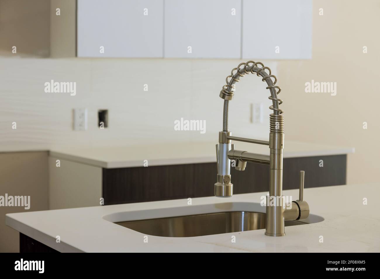 Installing new sink tape in the kitchen plumber with island sink Stock