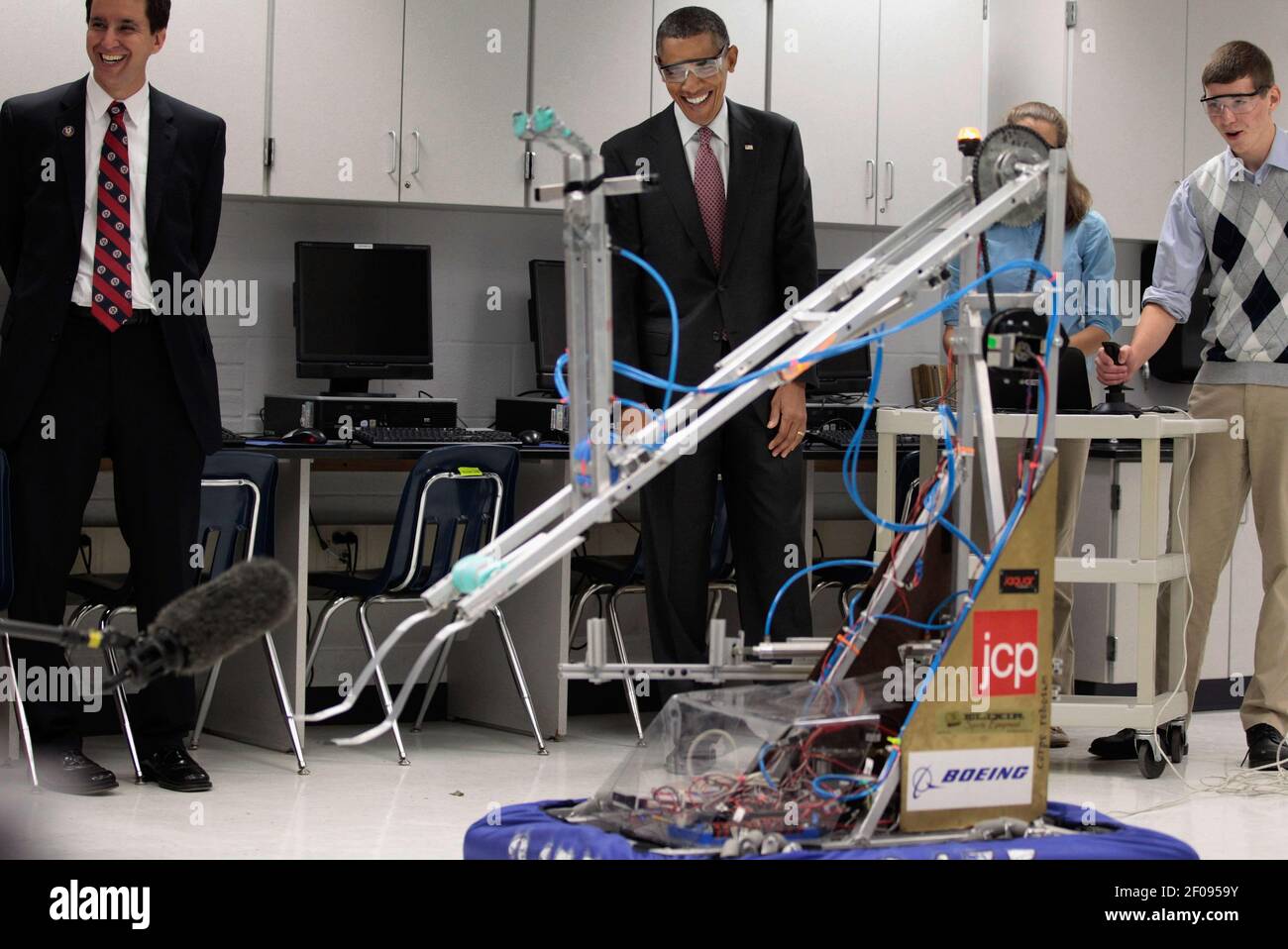 President Barack Obama watches a robot with students Robert Knight, III  (L),Morgan Ard, and Titus Walker, 8th grade students at Monroeville Jr.  High School in Monroeville, Alabama who won high honors at