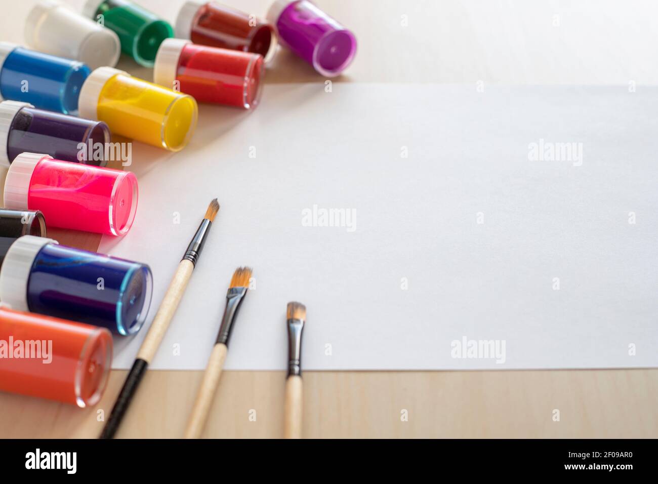 Artist and paint mockup with white paper on wooden background, brushes, paint and watercolor. Stock Photo