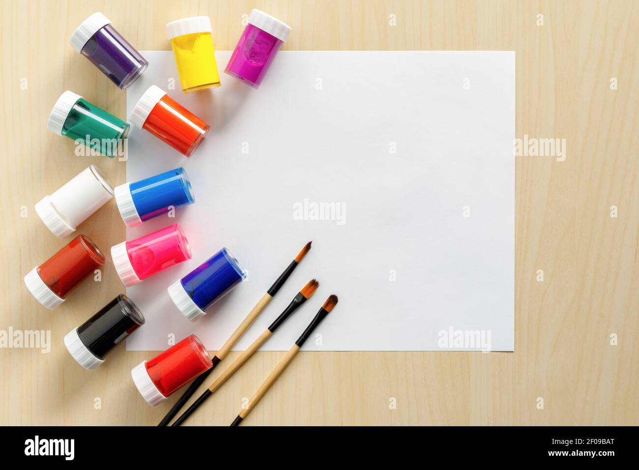 Artist and paint mockup with white paper on wooden background, brushes, paint and watercolor. Stock Photo