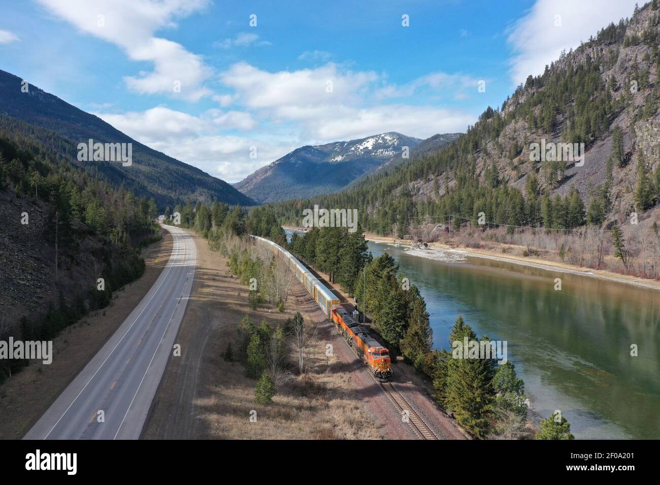 BNSF train hauling freight along the Kootenai River and Montana state highway 2. (Photo by Randy Beacham) Stock Photo