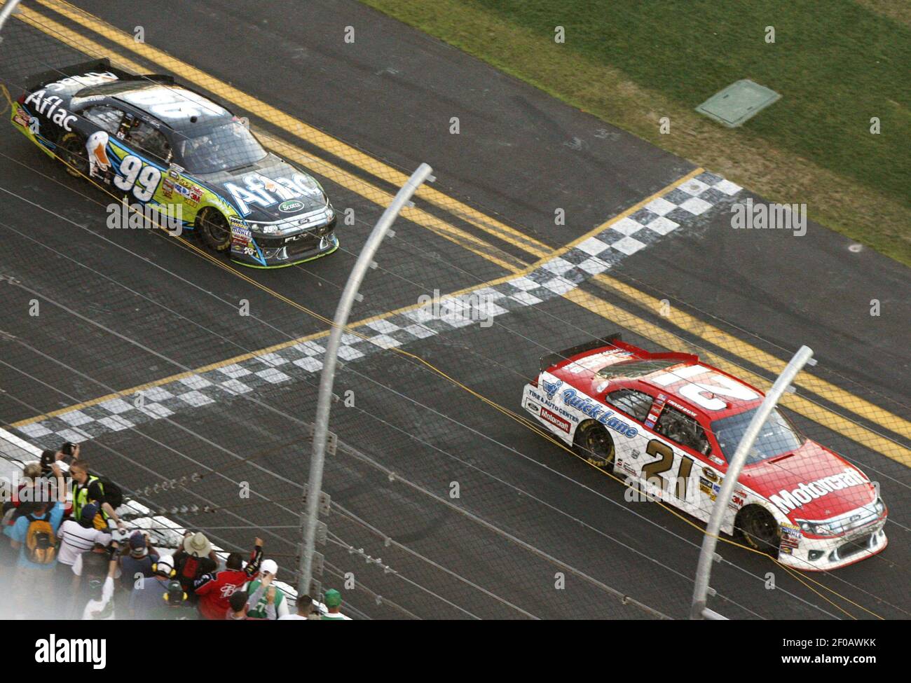 Trevor Bayne (21) crosses the finish line in front of Carl Edwards (99 ...