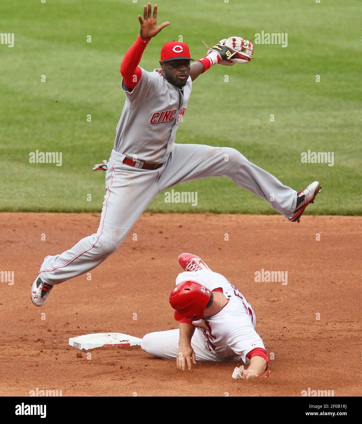 Cincinnati Reds second baseman Brandon Phillips, top, turns the double-play  as the St. Louis Cardinals' David Freese tries to break it up in the second  inning at Busch Stadium in St. Louis