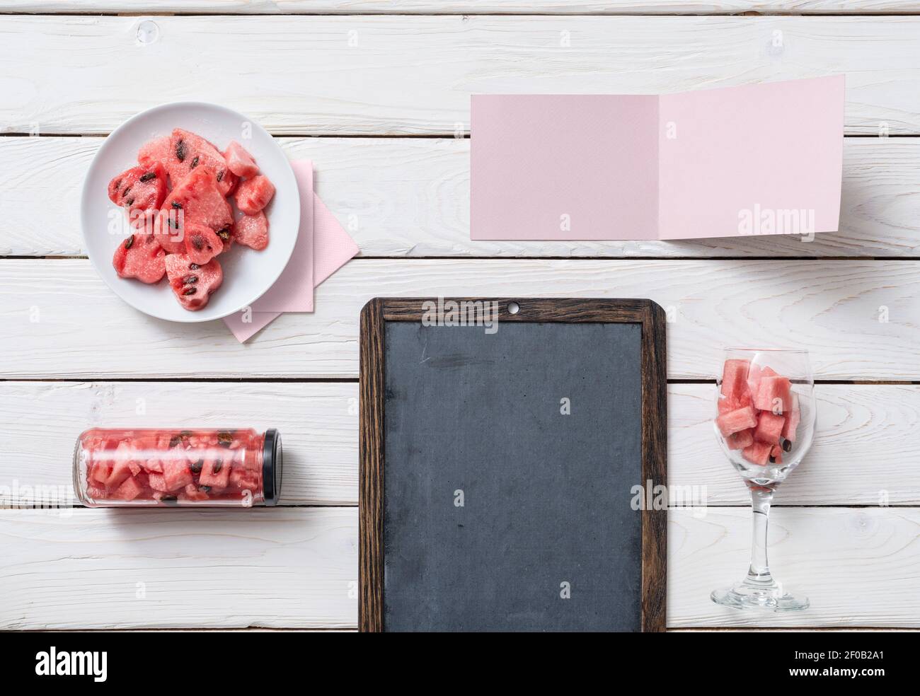 Chalkboard and tag on a desk with watermelon. Top view. Stock Photo