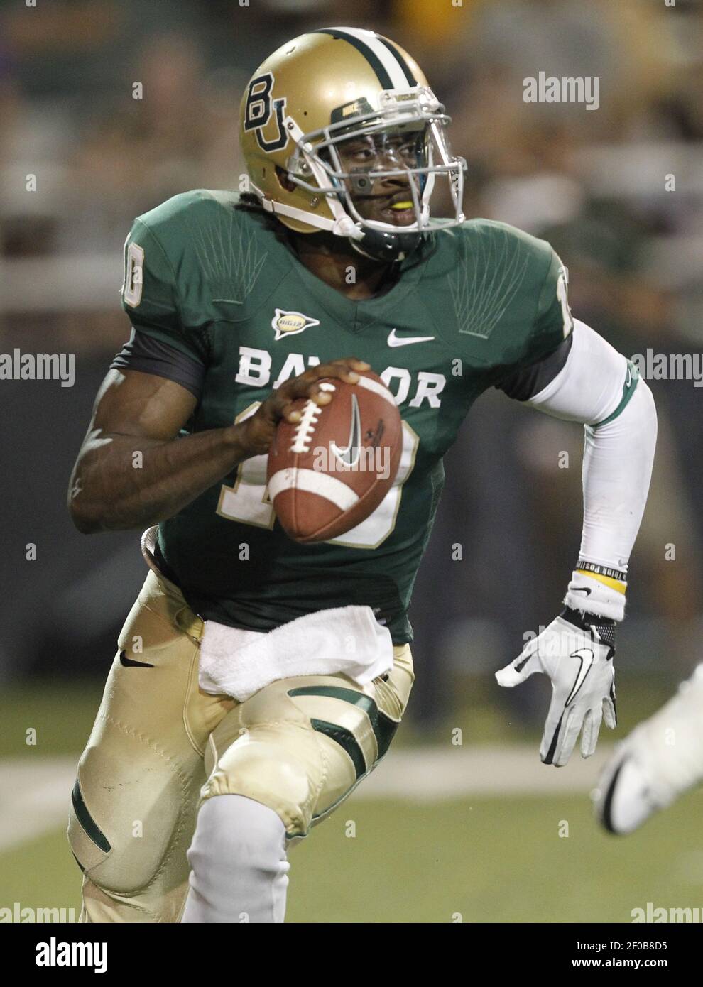 Baylor quarterback Robert Griffin III stands on the stage holding