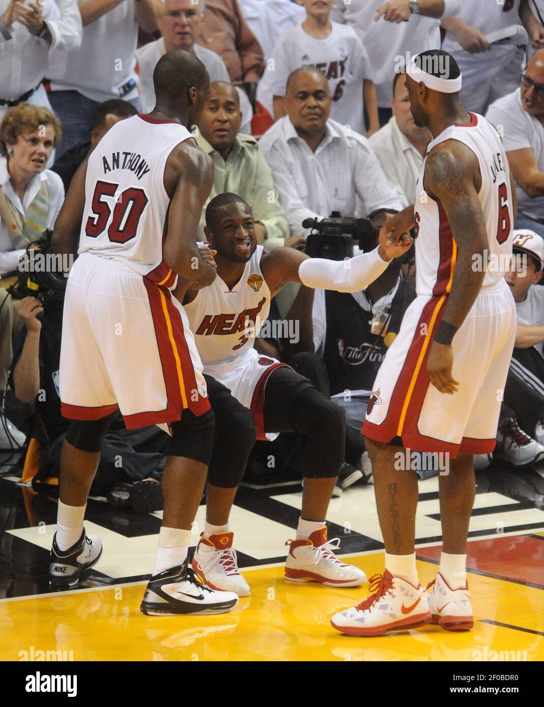 Miami Heat's Dwyane Wade is helped up by Joel Anthony and