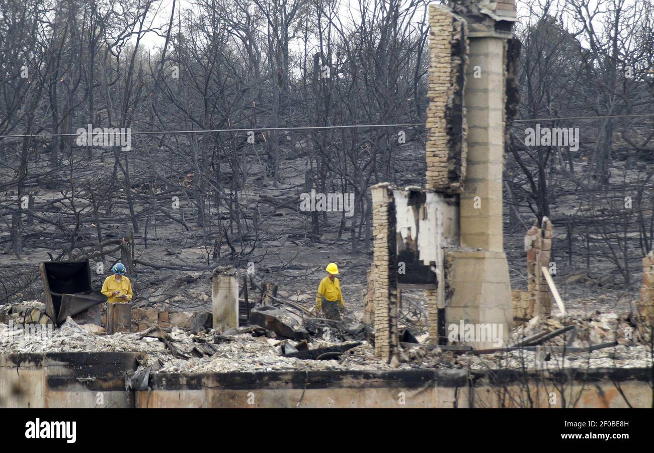 Members of a damage assessment team survey the destruction of a home in