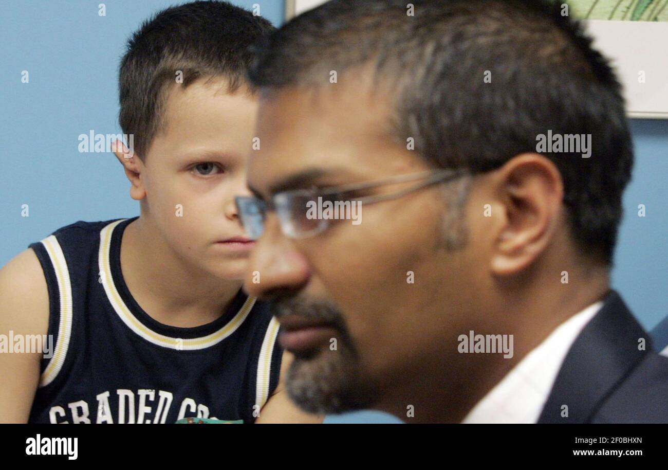Kyle Figuray listens intently as Dr. Ananth Murthy talks to his parents ...