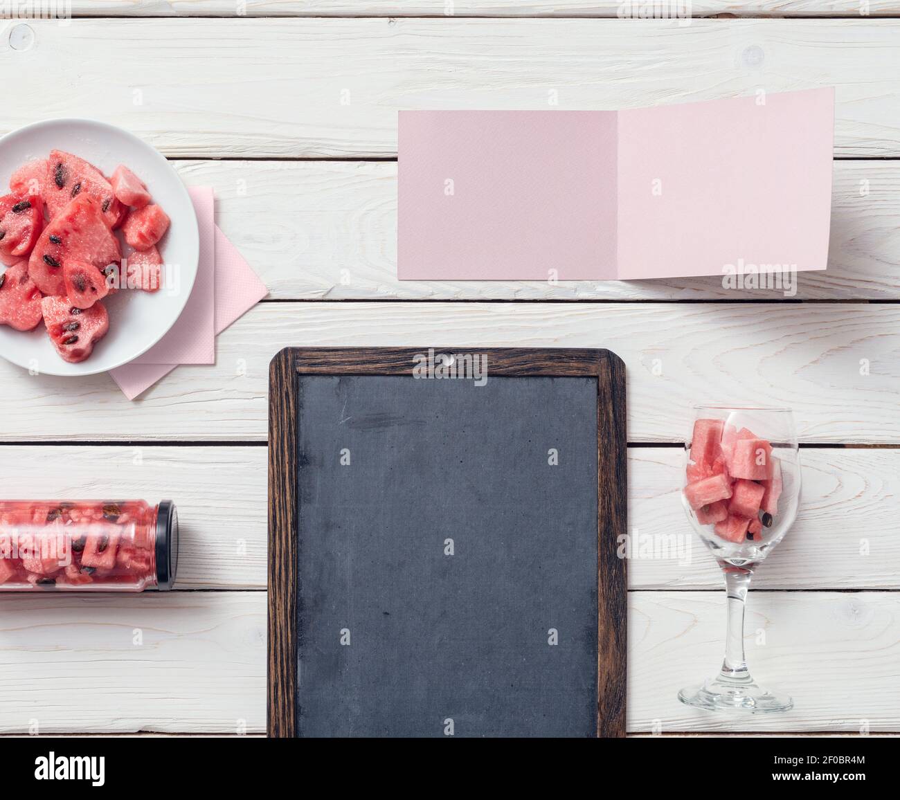 Chalkboard and tag on a desk with watermelon. Top view. Stock Photo