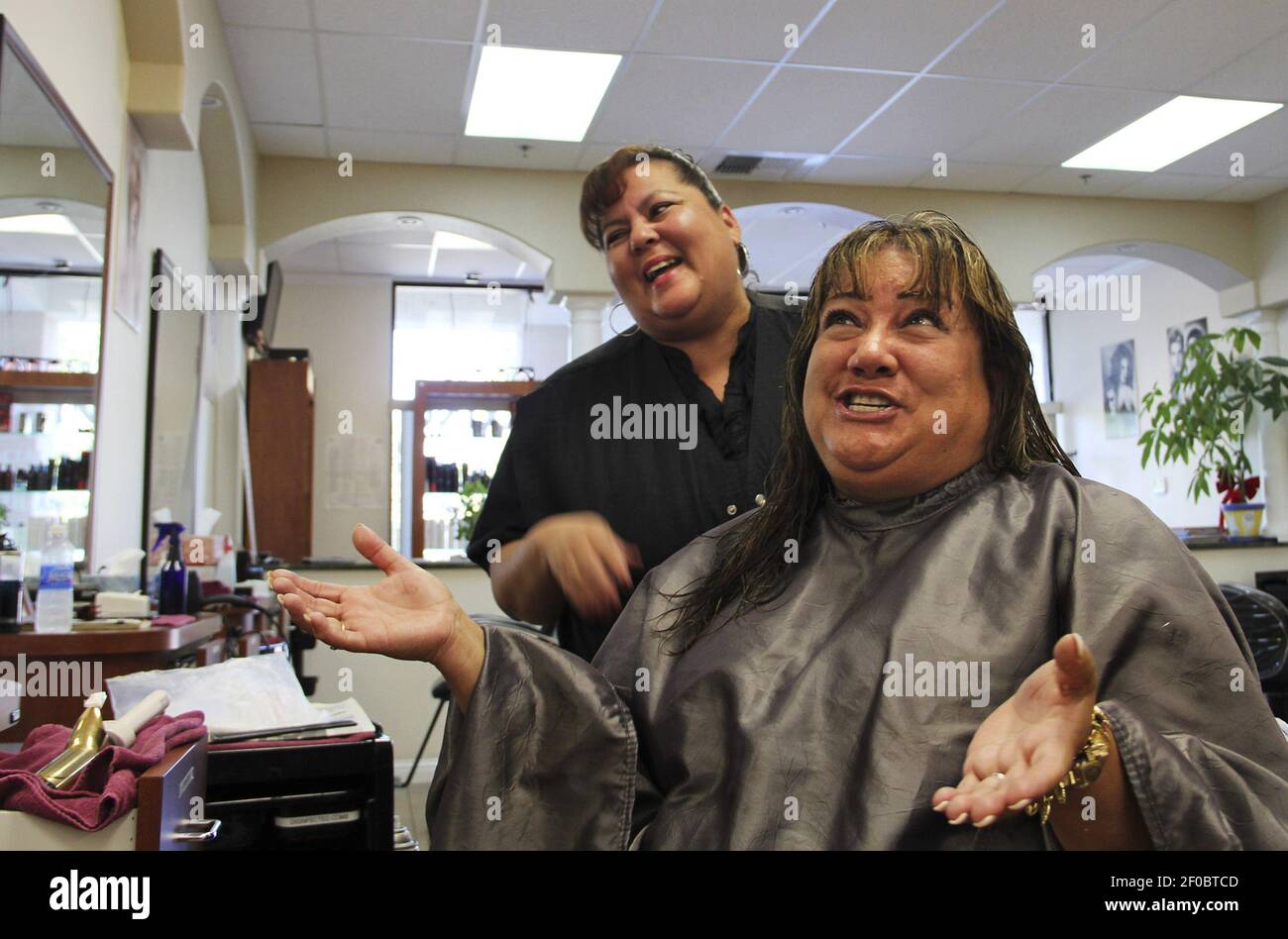 Valerie Reynoso-Piotrowski, foreground, tells the story of her 10-year  friendship with hair stylist Judy Johnson during her weekly appointment at  EZ Cuts in Elk Grove, California, August 17, 2011. (Photo by Whitney