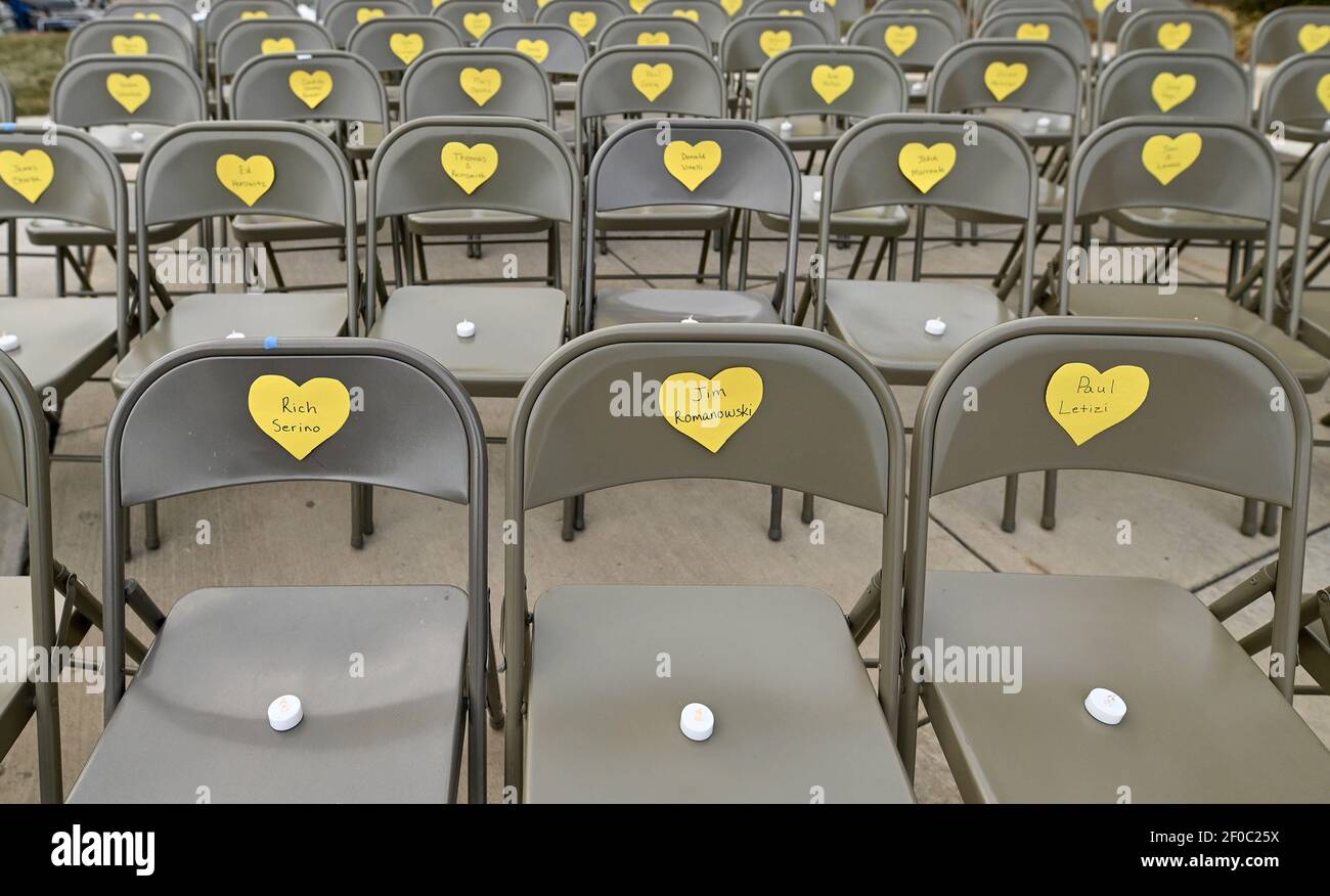 Wilkes Barre, United States. 06th Mar, 2021. Rows of empty chairs with heart symbols during the event. A memorial and vigil for victims of Covid19 was held outside of the Luzerne County Courthouse as part of the Yellow Heart Memorial project. An empty chair was placed to represent each of the lives lost in the community. Credit: SOPA Images Limited/Alamy Live News Stock Photo