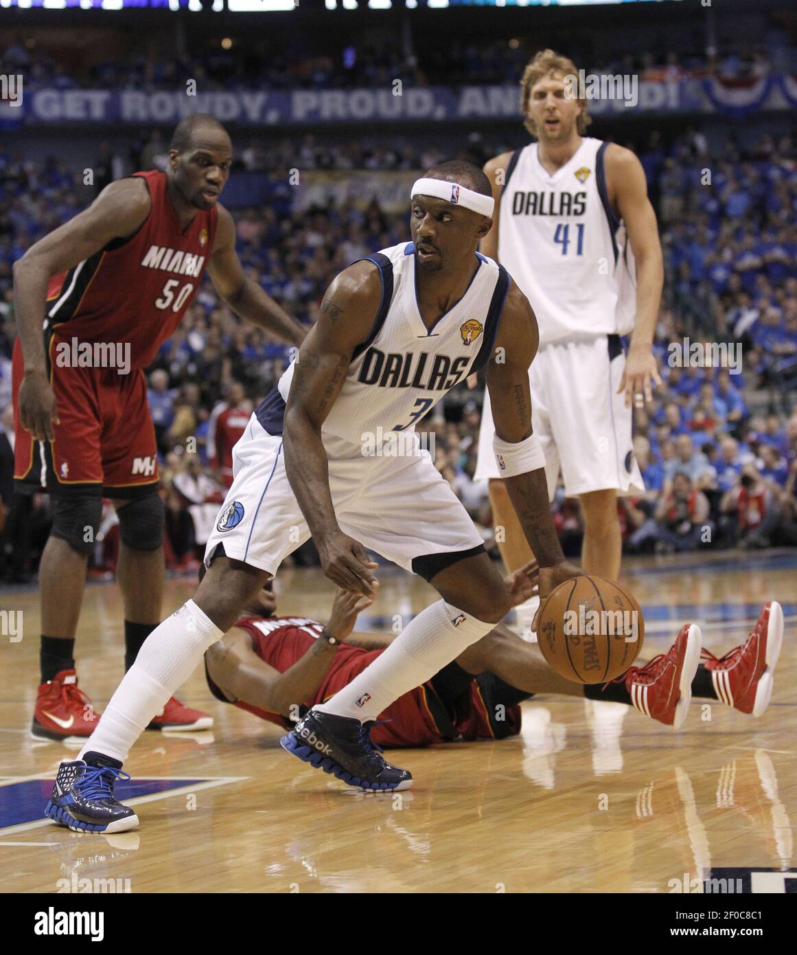 Dallas Mavericks' Jason Terry (31) dribbles as Miami Heat' Mario Chalmers  (15) falls down while Miami's Joel Anthony (50) and Dallas' Dirk Nowitzki  (41) look on at the AmericanAirlines Center in Dallas,