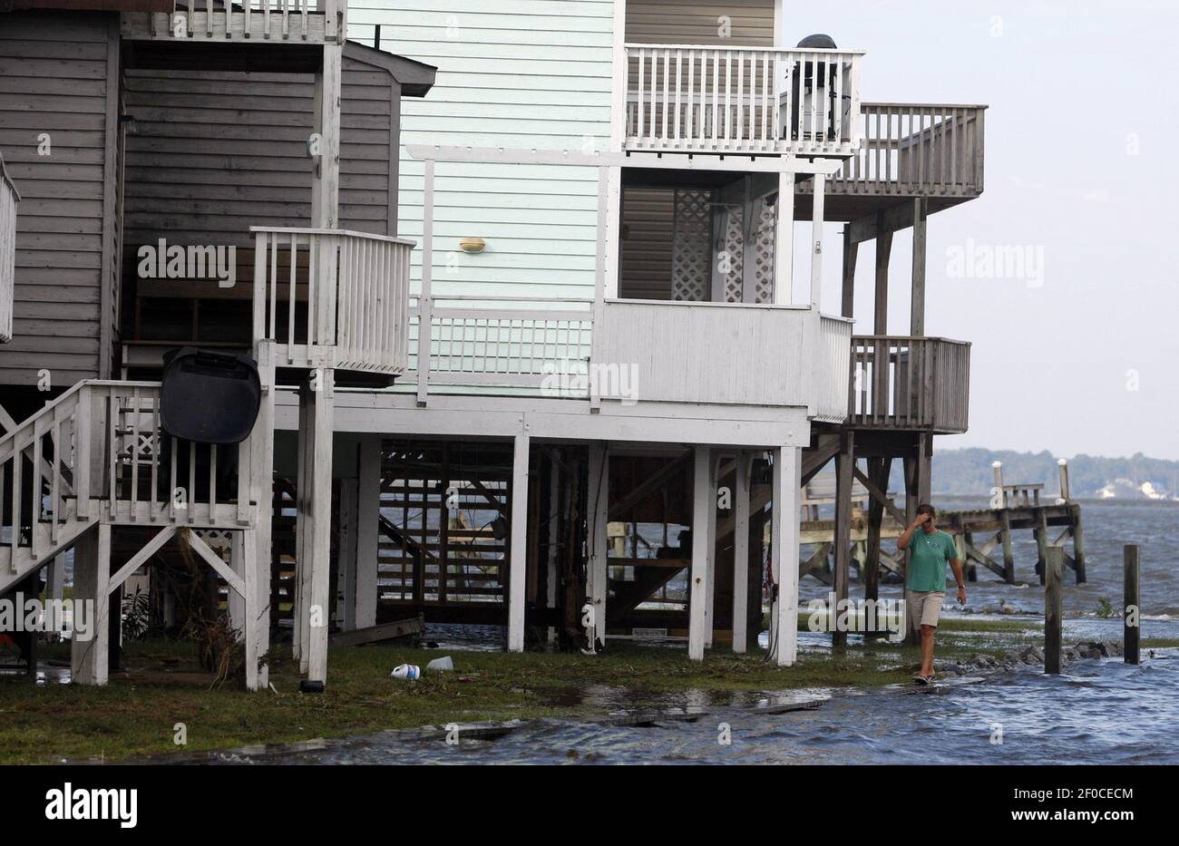 Julie Lane walks by flooded homes on Bay Drive in Kill Devil Hills ...