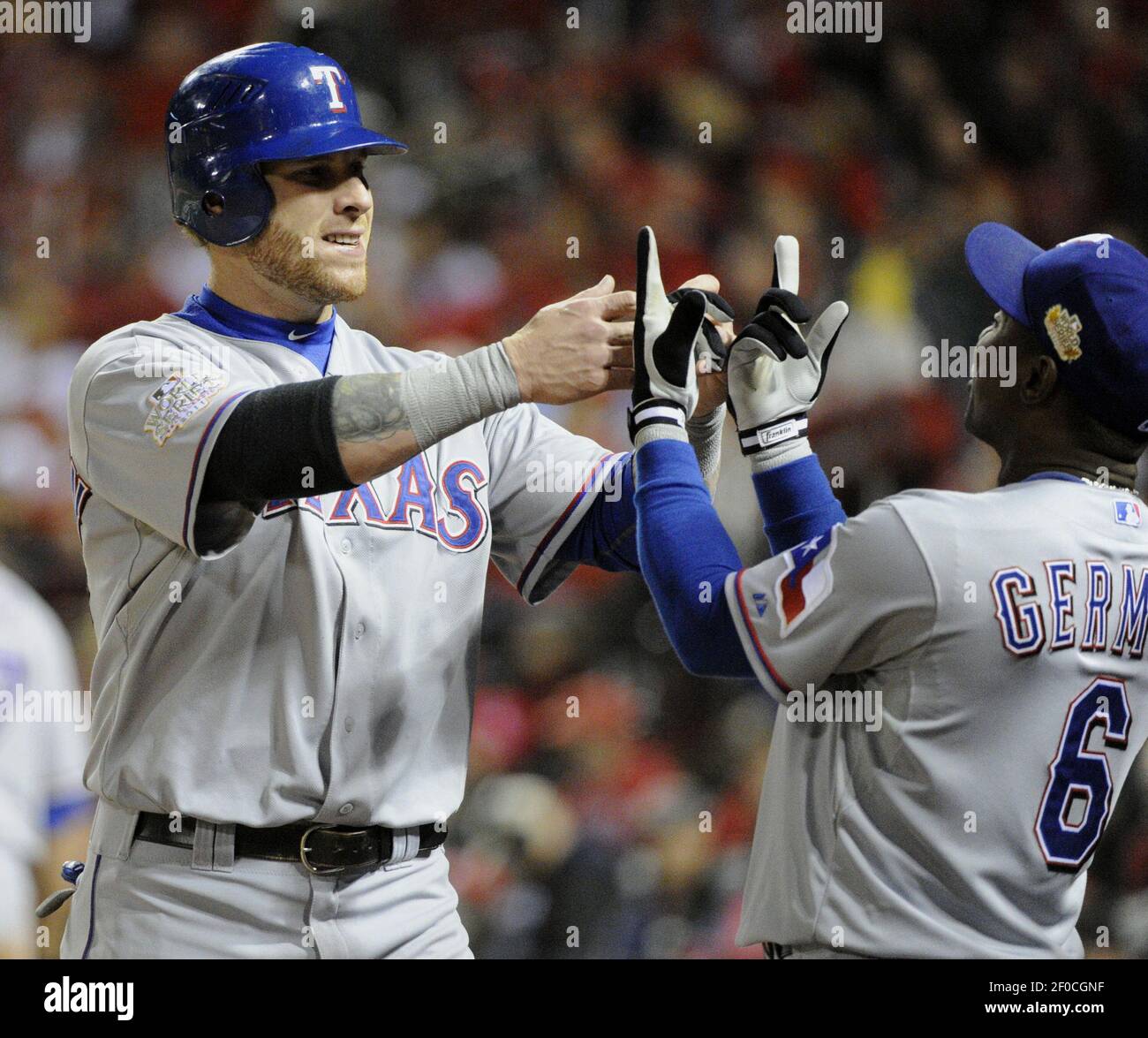 Texas Rangers' Josh Hamilton, left, and Esteban German rejoice after  Hamilton scored in the fifth inning against the St. Louis Cardinals in Game  6 of the World Series at Busch Stadium in