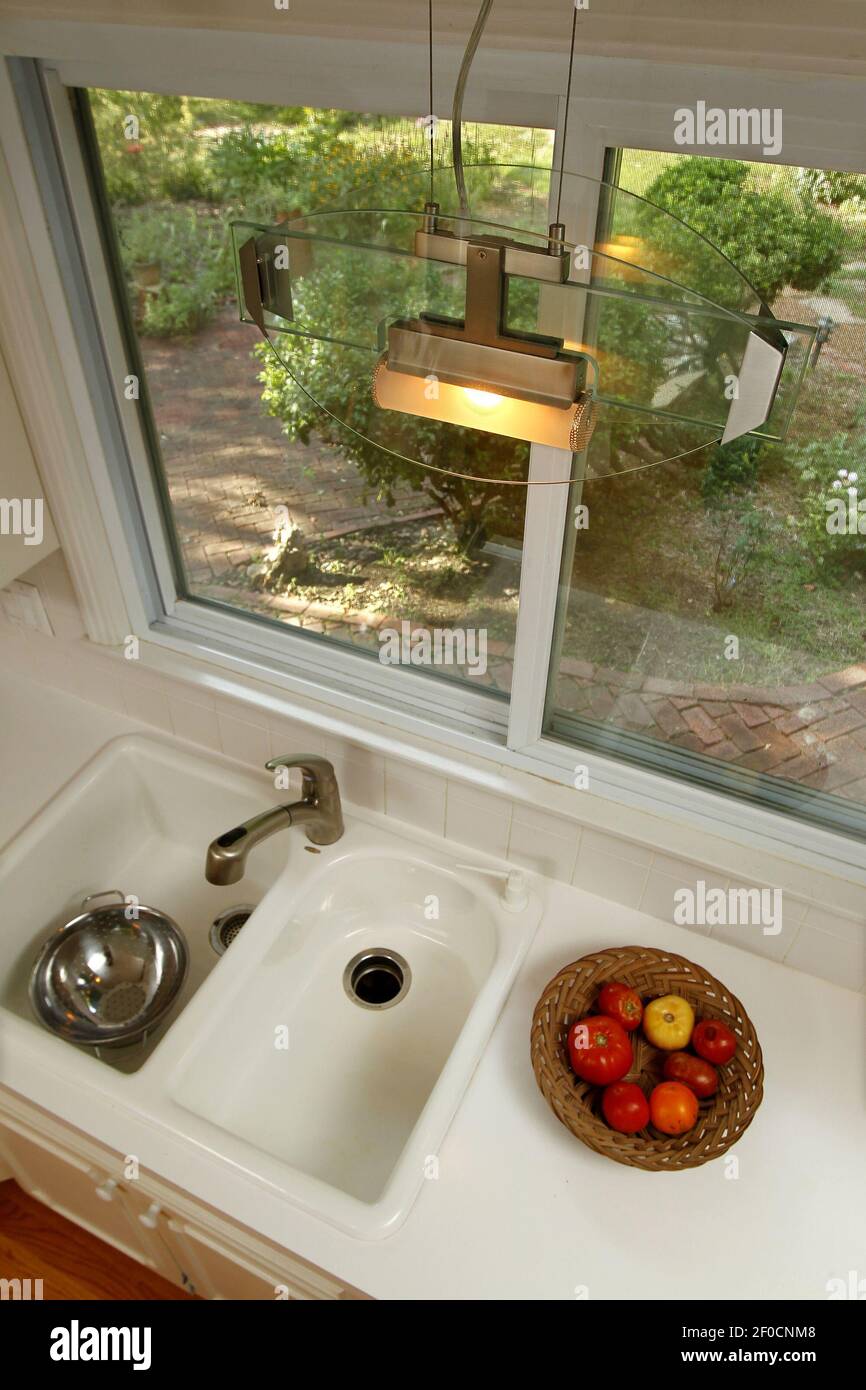 A lighting fixture shines light around the kitchen sink area of Sasha
