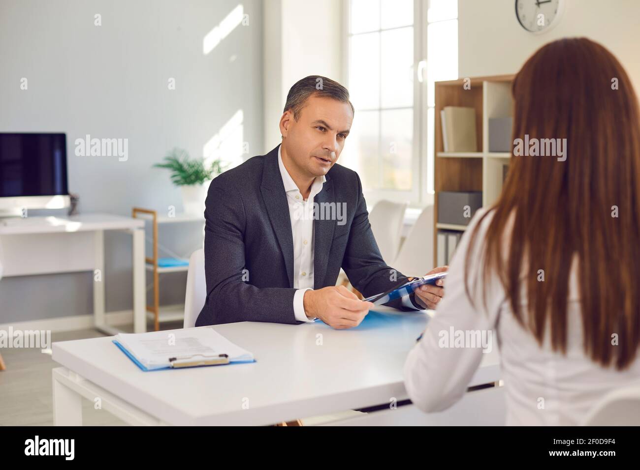 HR manager interviewing job candidate asking her questions concerning her work experience Stock Photo