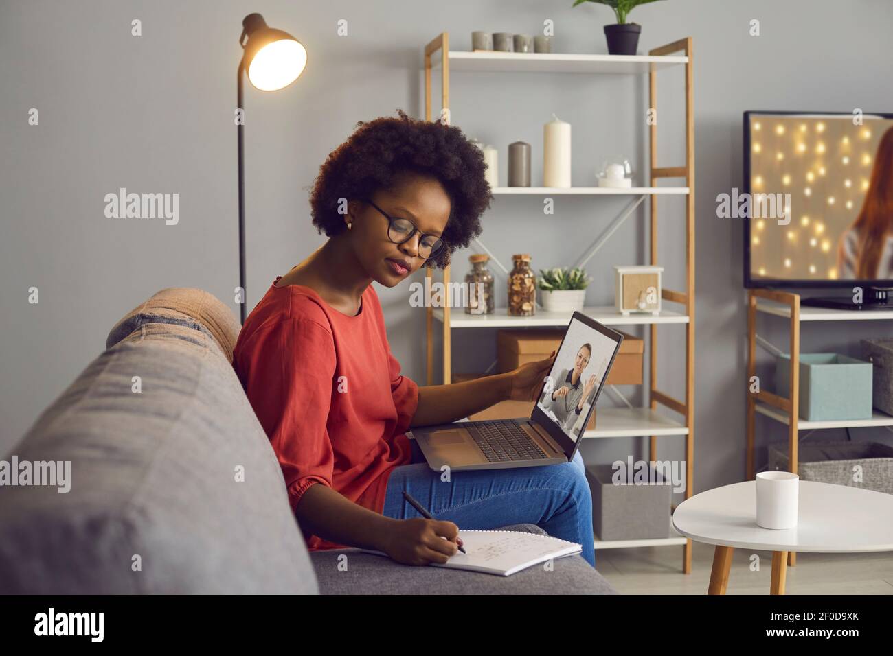 African american woman studying online remotely watching webinar at laptop Stock Photo