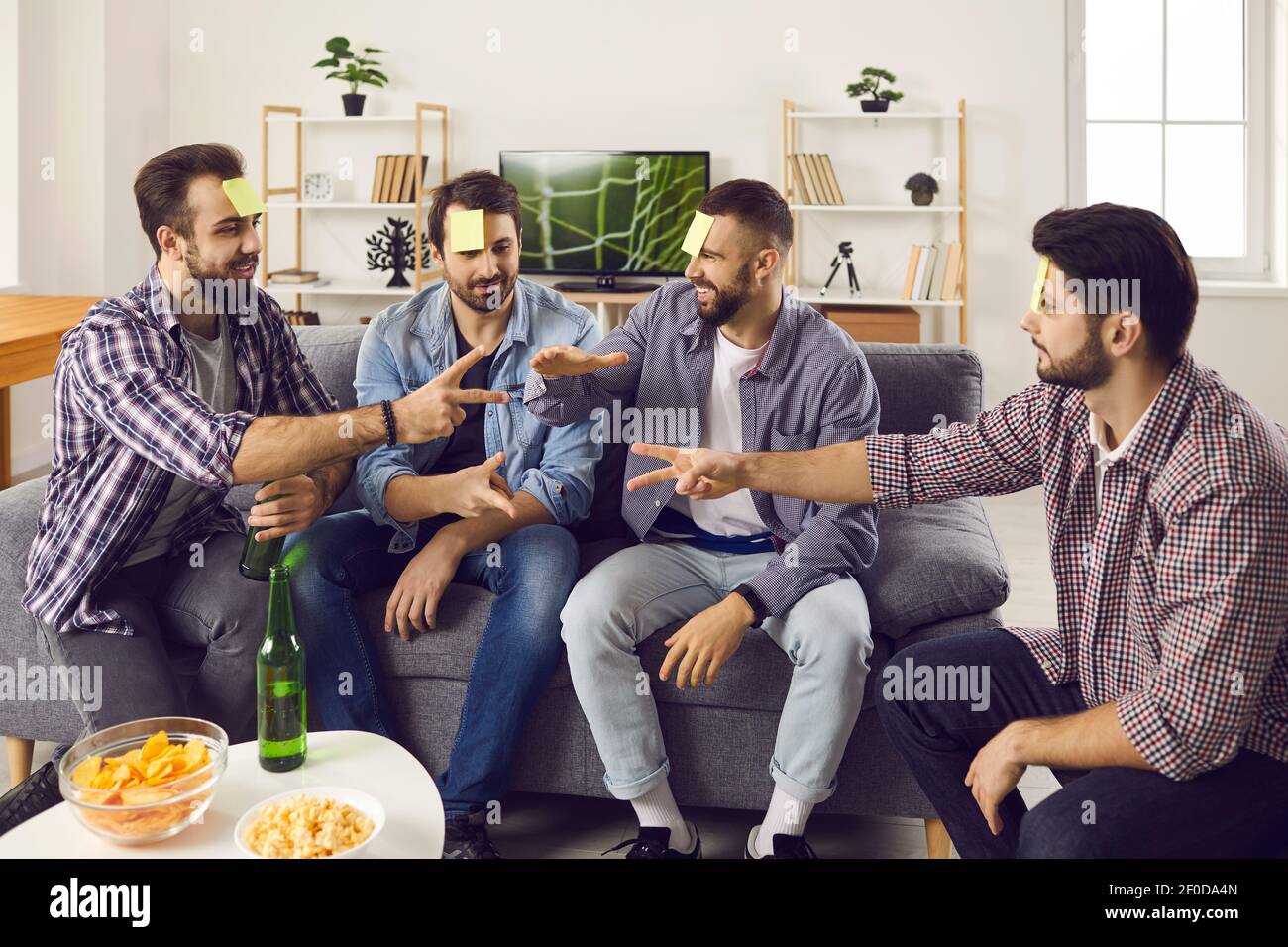 Bunch of young friends having a party, playing games and enjoying fun time together Stock Photo