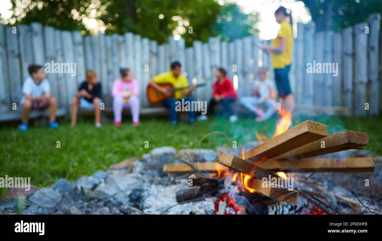 Happy kids having fun around camp fire Stock Photo