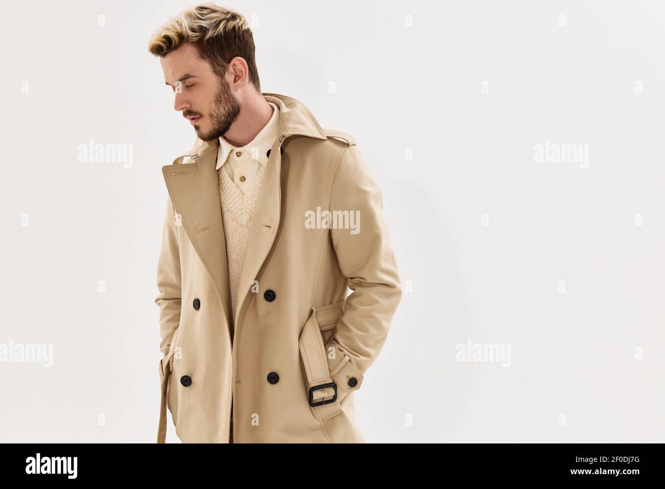 man in coat hands in pocket side view hairstyle modern style Stock