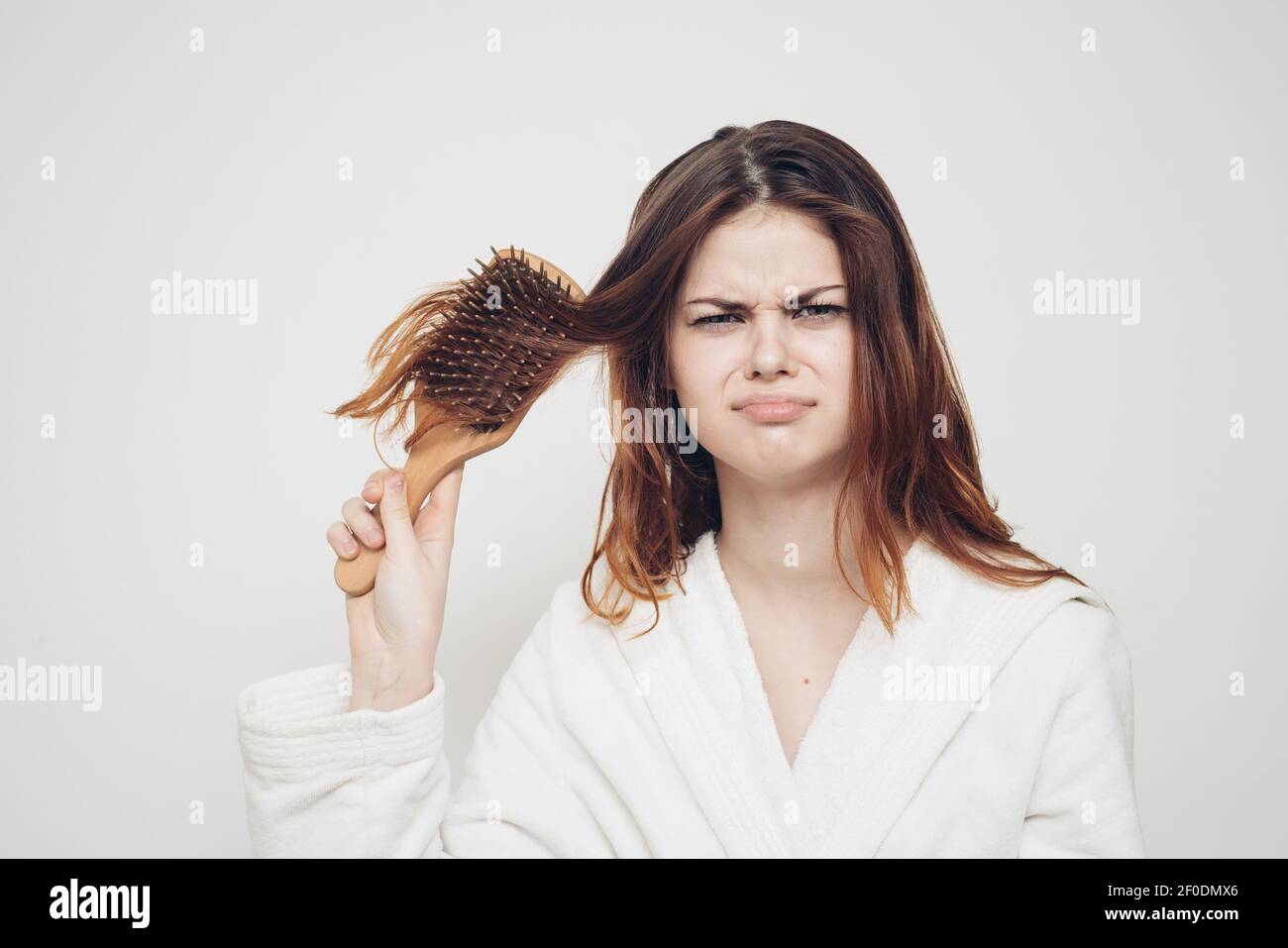 woman combing hair brittle ends split ends health problems Stock Photo