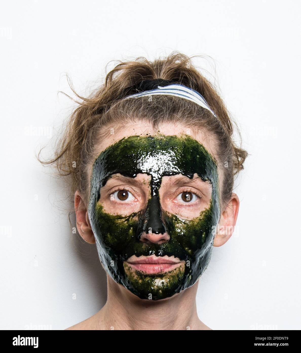 Woman face with spirulina skincare mask. Isolated, white background