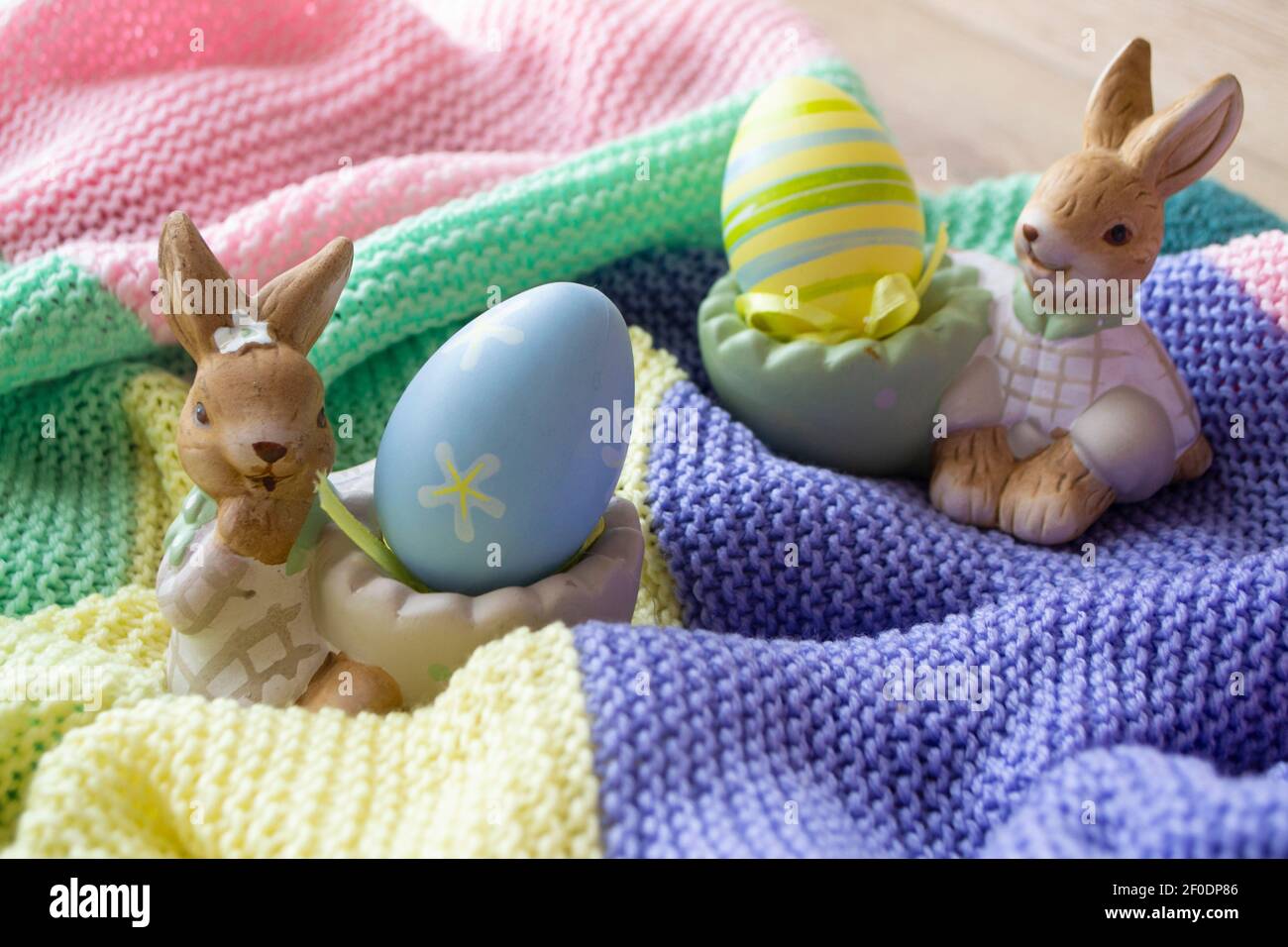 beautiful Easter eggs and bunny on colorful knitted background Stock Photo