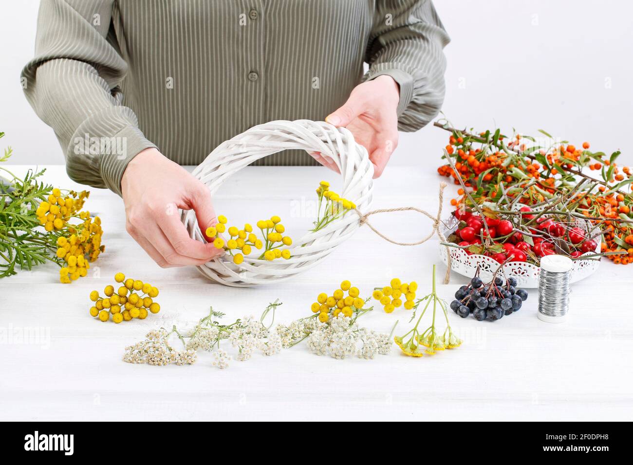 Florist at work: Woman shows how to make autumn wreath with rose hip ...