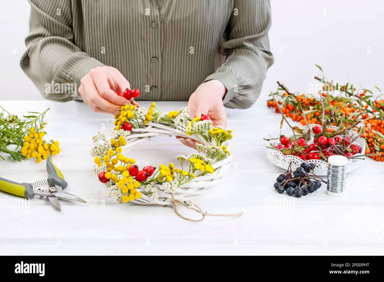 Florist at work: Woman shows how to make autumn wreath with rose hip ...